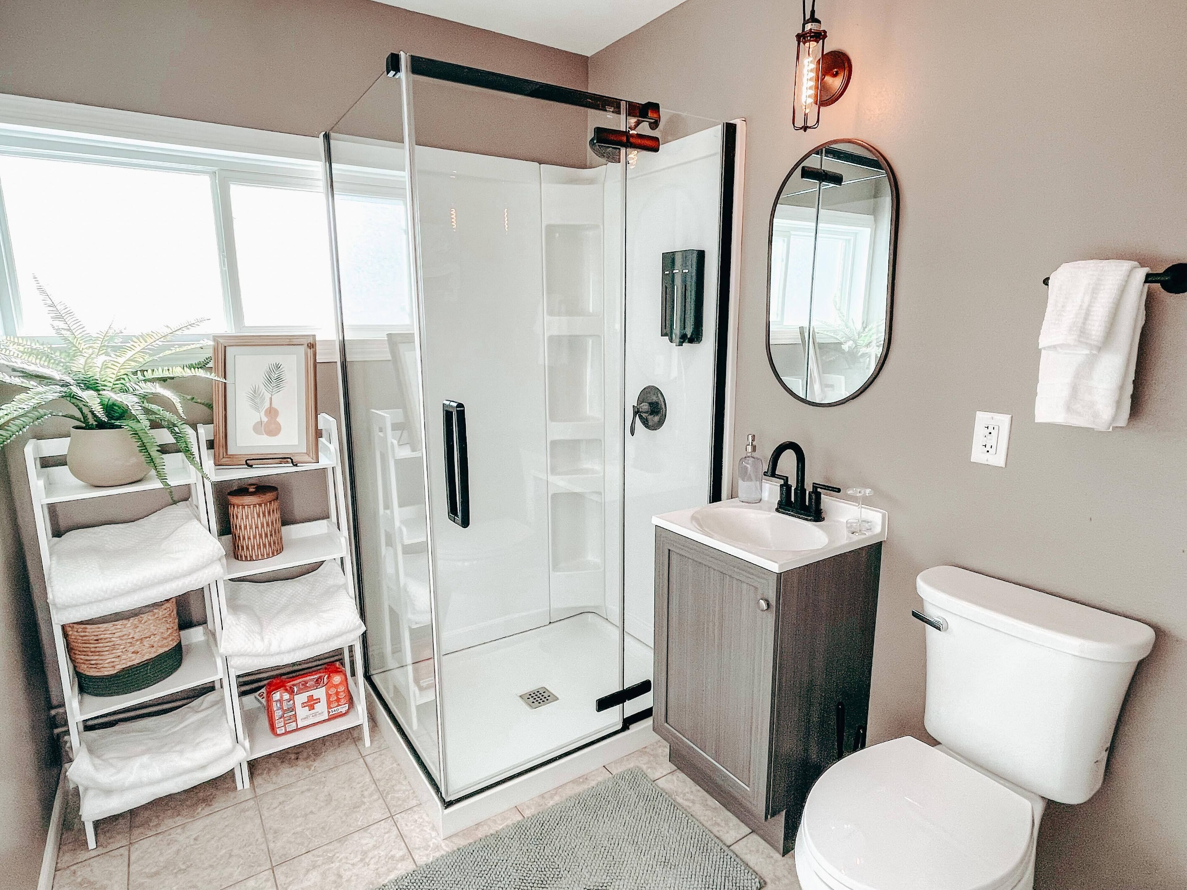 Een bad/douchecombinatie, een haardroger, handdoeken, zeep