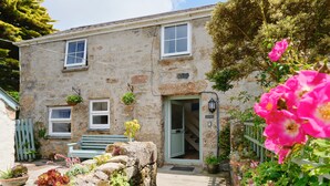 A stone building with a green door, a bench, and a staircase leading to an upper floor. - Farm Cottage, rural St Ives (Cornwall)