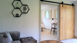 Ein modernes Wohnzimmer mit einem grauen Sofa, einem Couchtisch und einem sechseckigen Wandbild.