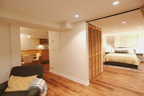 Ein Hotelzimmer mit Bett, Stuhl, Schreibtisch und Küchenzeile.