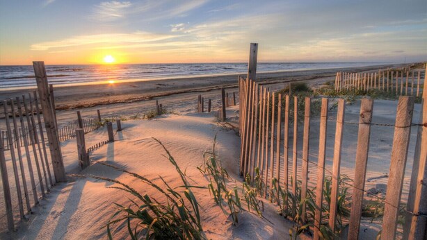 A wooden pathway leading to a beach with a sunset in the background. - Modern Beach Elegance: The Maples Retreat (Sunset Beach)