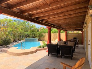 A covered outdoor area with a pool, wicker furniture, and a view of the surrounding greenery. - Paradise Found @ Tierra Del Sol Golf Course - Private Pool (Noord)