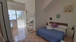Une chambre d’hôtel avec un lit, un bureau et une chaise. Il y a une fenêtre donnant sur l’extérieur.