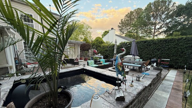 A backyard with a swimming pool, outdoor furniture, a bird sculpture, and a potted plant. - 2,300 Sqft 2 Story Home With 3 Bedrooms 21/2 Bathrooms in Apex North Carolina (Apex)