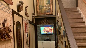 A hallway with a staircase, a TV displaying 'HAVE FUN', and a 'WELCOME HOME' sign. - 2,300 Sqft 2 Story Home With 3 Bedrooms 21/2 Bathrooms in Apex North Carolina (Apex)