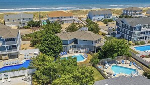Zona residencial con varias casas, piscina y vista al mar.