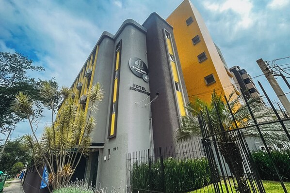A hotel with a modern design, featuring a prominent vertical structure and a yellow facade. - Esquina Batel Hotel (Curitiba)