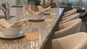 Un comedor con una mesa larga, varias sillas y una lámpara de techo moderna.
