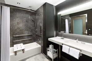 Bathroom features a standalone bathtub, vanity with mirror, and towel rack.
