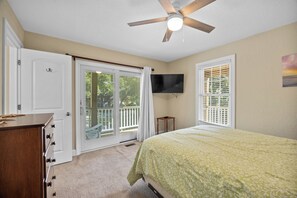 A bedroom with a bed, a dresser, a ceiling fan, a TV, and a balcony door. - Renovated! Gorgeous Views, Private Pool, Hot Tub, close to Beach, SS0028 (Southern Shores)