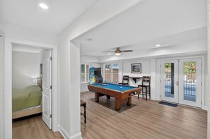 A room with a pool table, a ceiling fan, and a view through a glass door. - Renovated! Gorgeous Views, Private Pool, Hot Tub, close to Beach, SS0028 (Southern Shores)