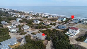 Luftaufnahme einer Küstenwohngegend mit Häusern, Straßen und einem Strand.