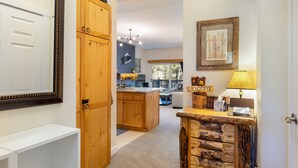 A modern kitchen with wooden cabinets, a central island, and a welcoming 'WELCOME' sign. - On Keystone Lake/Shared Hot Tub/Quick Shuttle Ride to the Lifts (Keystone)