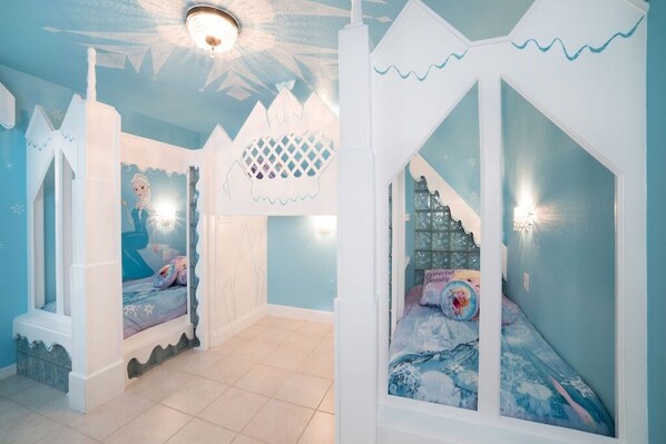 A children's bedroom with two bunk beds, each with a castle-like canopy.