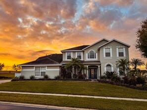 A two-story house with a front porch, a garage, and a well-maintained lawn.