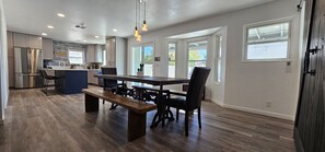 A modern kitchen with a central island, built-in appliances, and large windows.