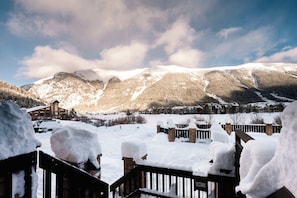 Un paisaje montañoso cubierto de nieve con un conjunto de edificios en primer plano.