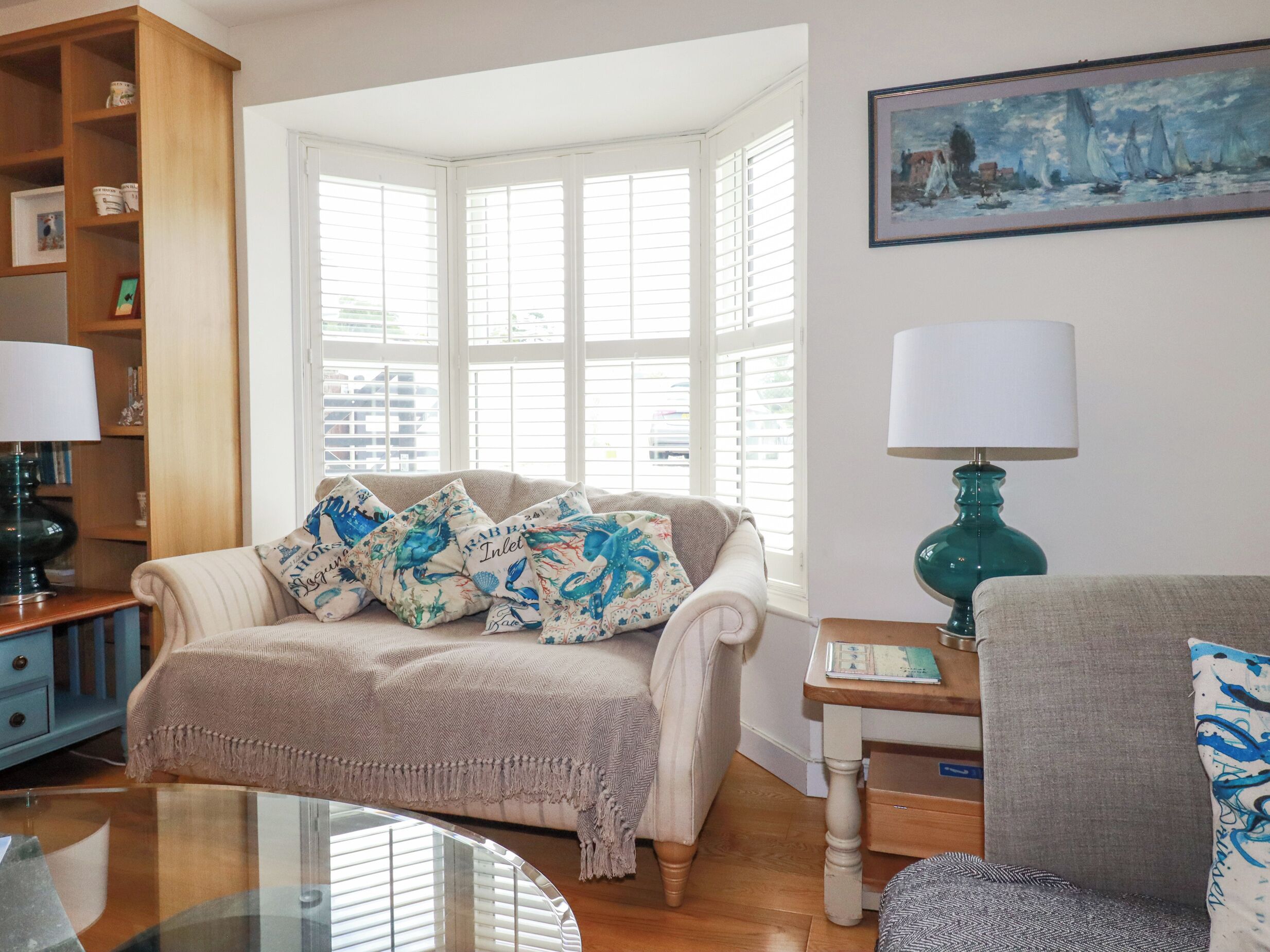 A cozy living room with a sofa, a coffee table, and a lamp.