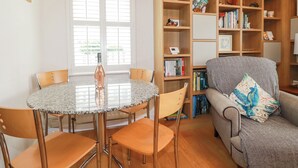 Un salon avec une table ronde, des chaises, une bibliothèque et un canapé.