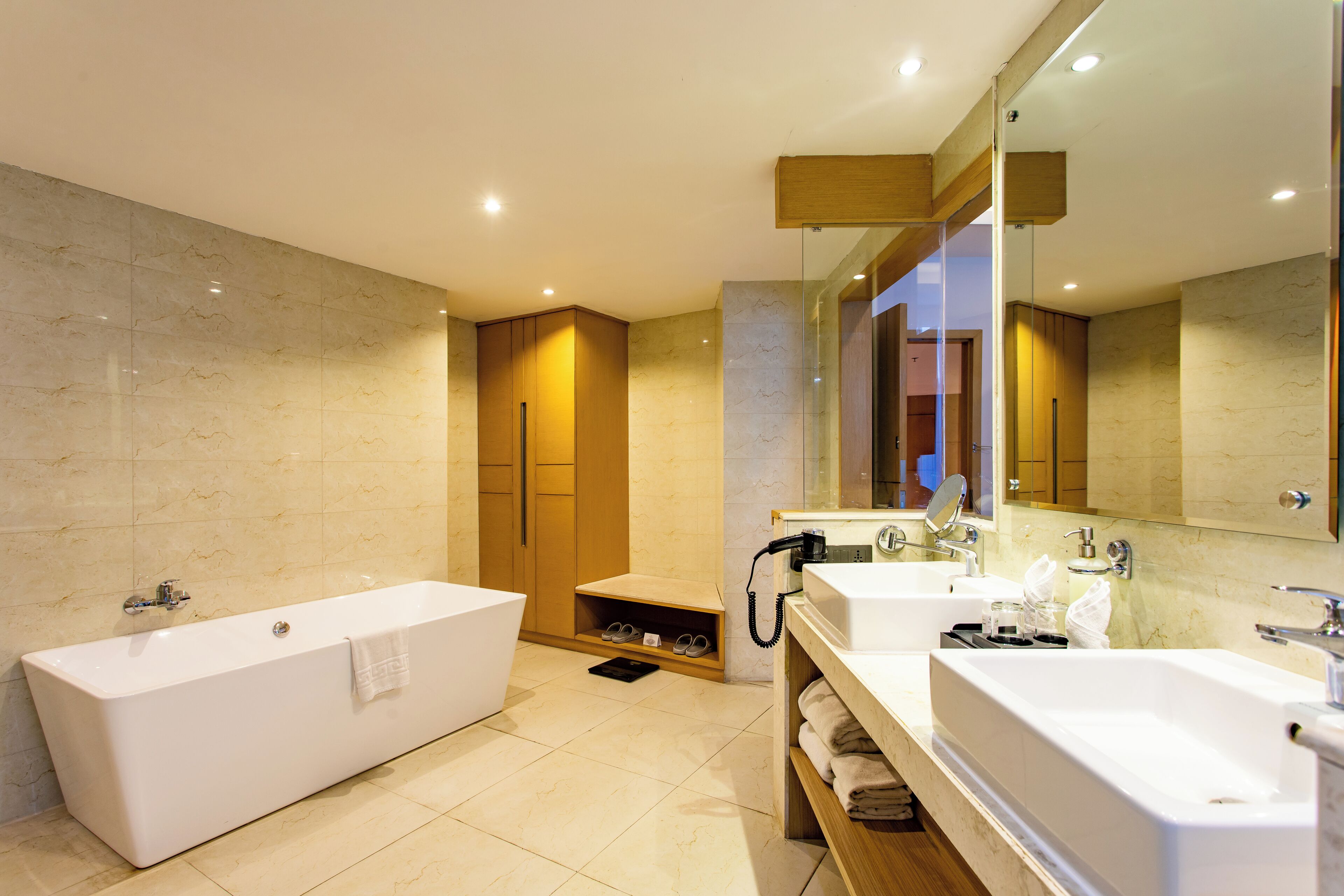 Un baño moderno con una bañera grande, dos lavamanos y una ducha a ras de suelo.