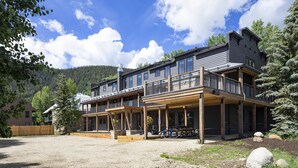 A two-story lodge with a wooden deck and a covered porch. - Vaquera House (Crested Butte)