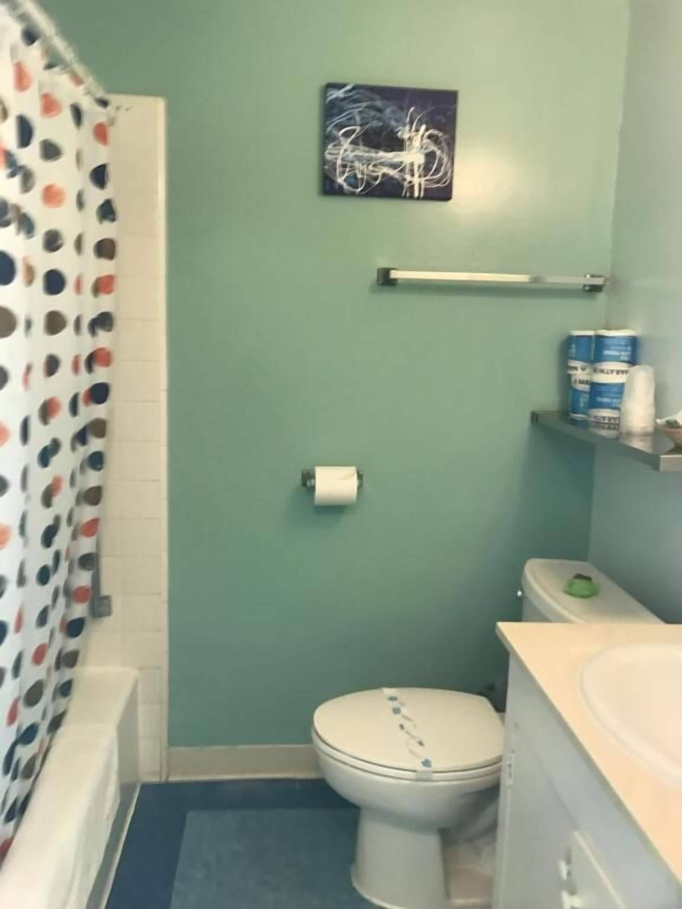 Eenvoudige kamer | Badkamer | Een bad/douchecombinatie, handdoeken