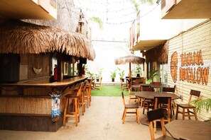 Een buitenterras met rieten parasols en houten meubilair.