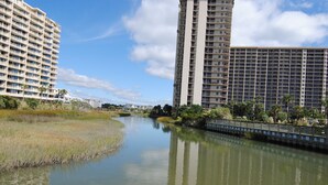 A river with a bridge, surrounded by tall residential buildings. - OASIS BEACH RETREAT NORTH MYRTLE BEACH (Myrtle Beach)