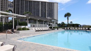 A hotel pool area with a clear view of the pool, lounge chairs, and a covered seating area. - OASIS BEACH RETREAT NORTH MYRTLE BEACH (Myrtle Beach)