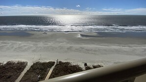 Une plage offrant une vue dégagée sur l’océan et sur une côte lointaine.