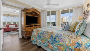Ein geräumiges Schlafzimmer mit einem großen Bett, einem Fernseher und einem Balkon mit Blick auf die Stadt.