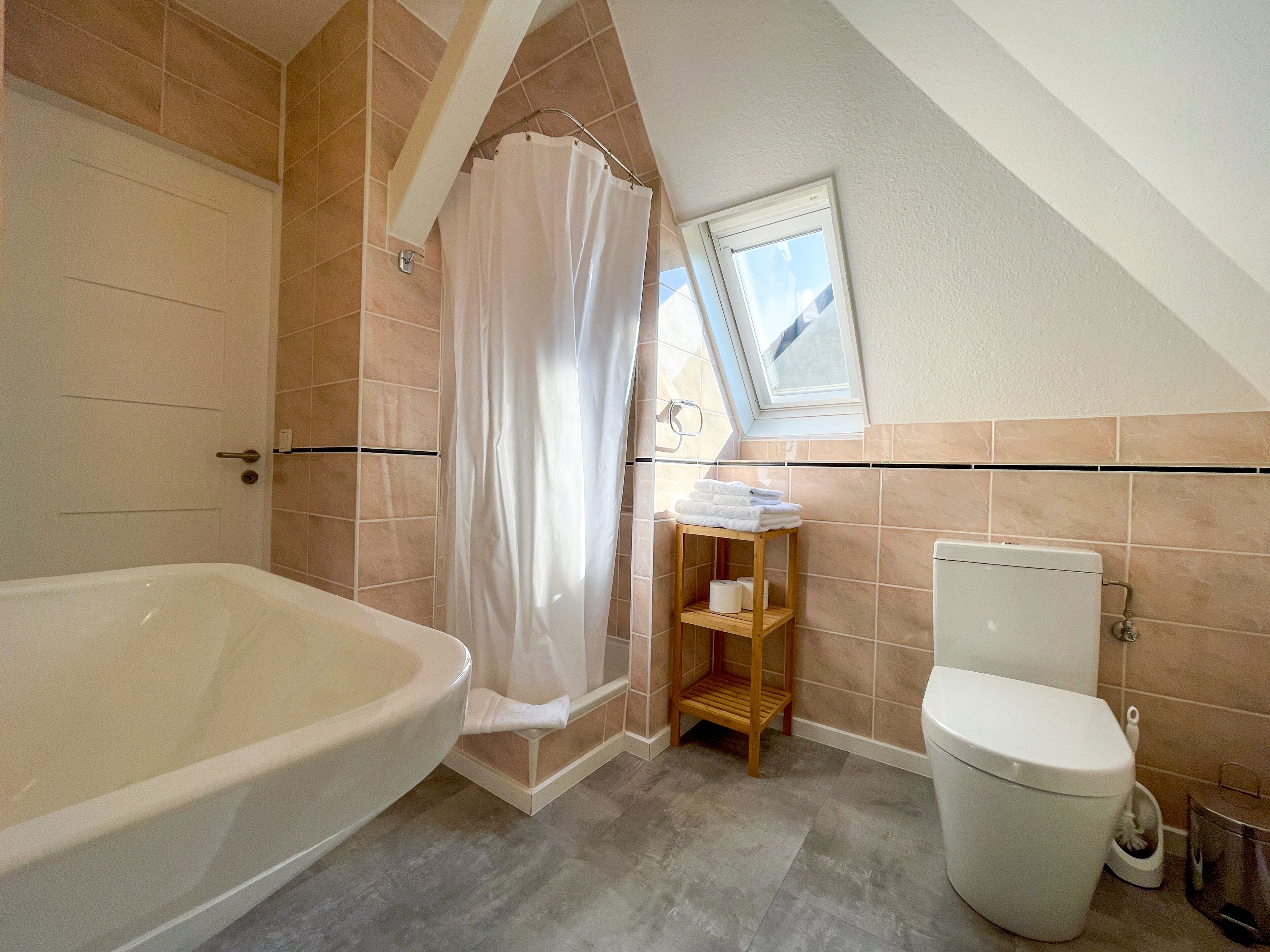 Une salle de bain avec une baignoire, des toilettes et un rideau de douche.