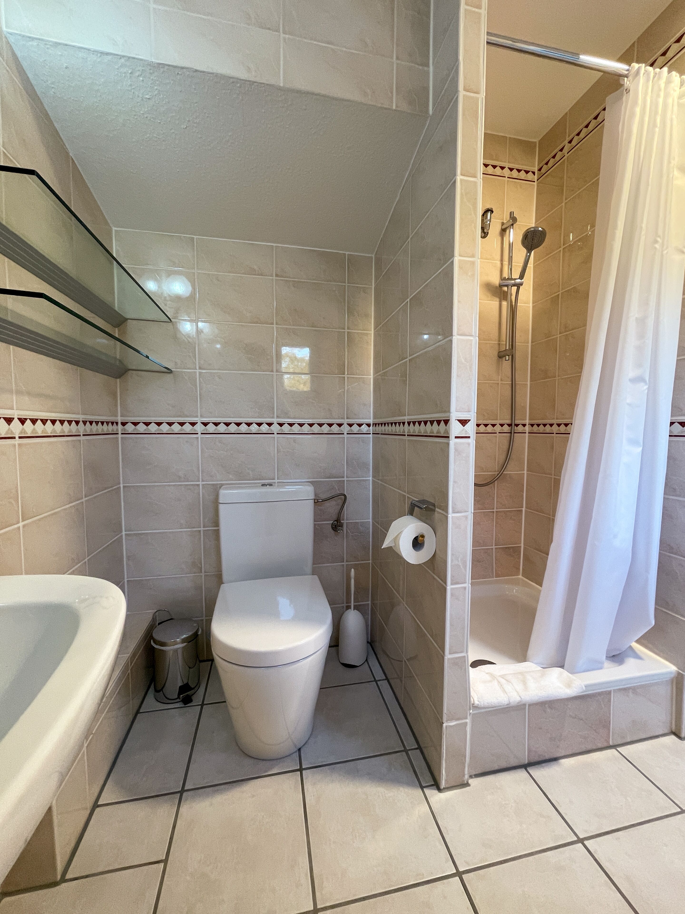 Une salle de bain équipée de toilettes, d’un lavabo et d’une douche.