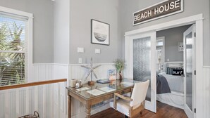 Een kamer met een strandthema, met een bureau, stoel en een bed met een strandkussen.