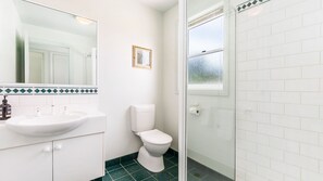 A bathroom with a white sink, a toilet, and a shower area. - Centrally located with river views (Port Fairy)