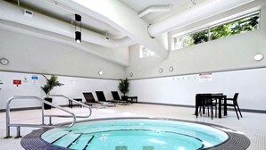 A swimming pool with a tiled deck, lounge chairs, and a table with chairs. - 2BR,2BTR with AC condo in vancouver 6 guests parking (Vancouver)