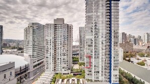 A high-rise residential building with multiple balconies and a modern architectural design. - 2BR,2BTR with AC condo in vancouver 6 guests parking (Vancouver)
