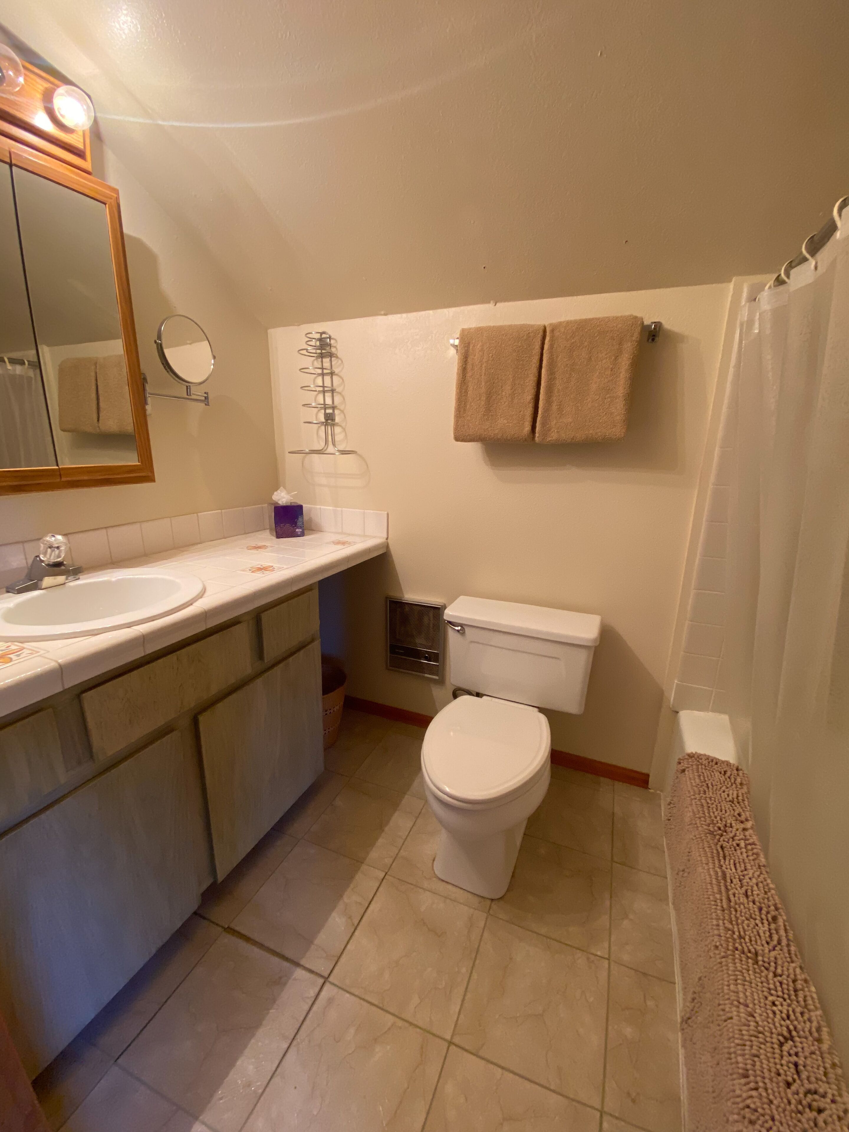 Ein Badezimmer mit Waschbecken, Spiegel, Toilette und Handtuchhalter.