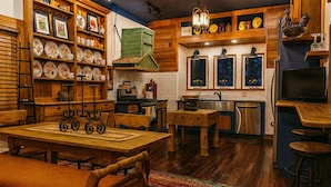 Une cuisine chaleureuse avec des meubles en bois, une table à manger et un tapis aux couleurs vives.