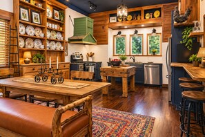 A kitchen with wooden cabinetry, a dining table, and bar stools.