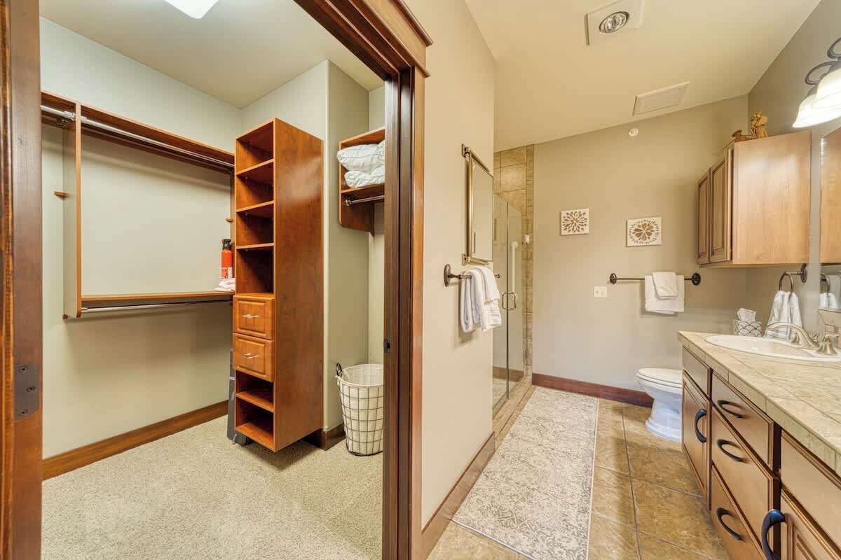 Un baño con cabina de ducha, inodoro, lavabo y tocador con cajones.