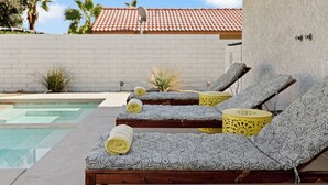 Un espace aménagé au bord de la piscine, avec des chaises longues et une petite piscine.