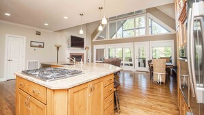 A spacious kitchen with a large island, wooden cabinets, and a stone countertop. - "A Place To Land" on WATTS BAR LAKE with a PRIVATE BOAT DOCK! (Spring City)