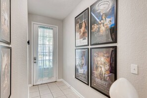 Walk down this hallway lined with iconic movie posters and discover a door with a unique frosted glass panel.