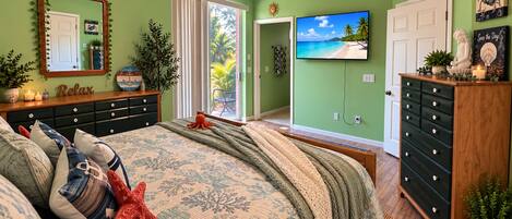 A bedroom with a bed, dresser, and a ceiling fan.