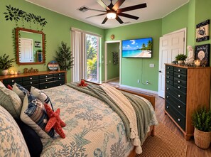 Une chambre à coucher avec un lit, une commode et un ventilateur de plafond.