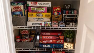 Una sala de juegos con estantes llenos de juegos de mesa y un cartel anunciando un día de juegos.