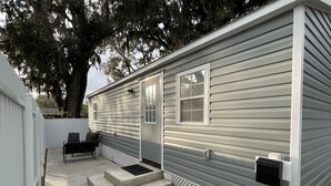 A single-story mobile home with a front porch, a mailbox, and a bench. - Cozy and comfortable tiny house  (Plant City)