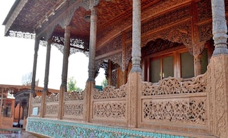 An intricately carved wooden structure with columns and detailed patterns.