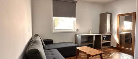Una sala de estar moderna con un sofá seccional, una mesa de centro de madera y un mueble bajo para la televisión.